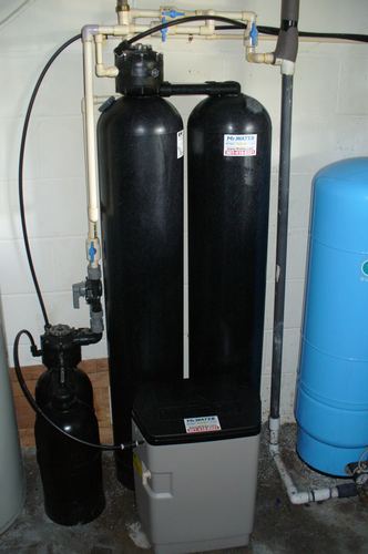 Twin water softener and filter tanks with a brine tank and blue well pressure tank