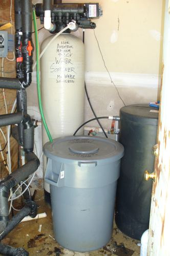 Autotrol Magnum 120K water softener with a chlorine storage tank in a tight utility closet