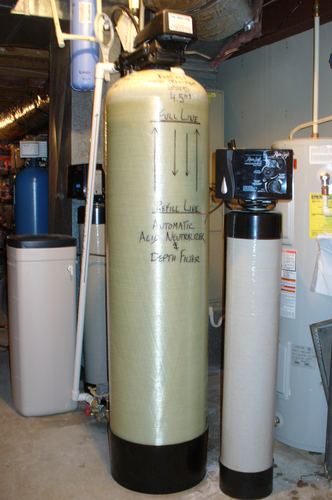 Automatic acid neutralizer and RainSoft depth filter installed in a basement with a water softener