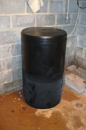 Water treatment tank installed in a basement corner