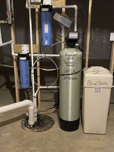 EcoSoft 64K electronic demand water softener with a brine tank in a basement