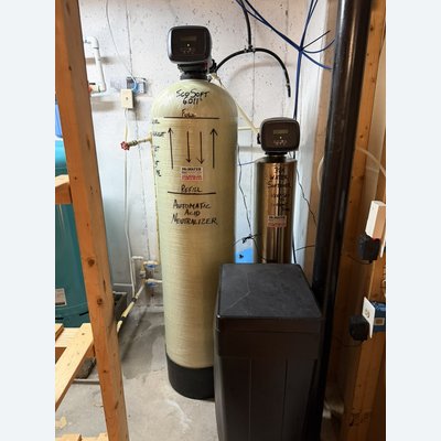 Acid neutralizer and water softener tanks installed side by side with a brine tank