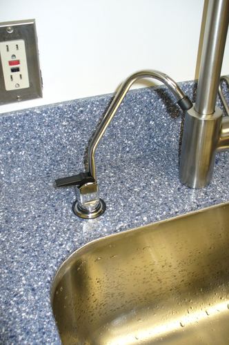 Close-up of a reverse osmosis drinking water faucet at a kitchen sink