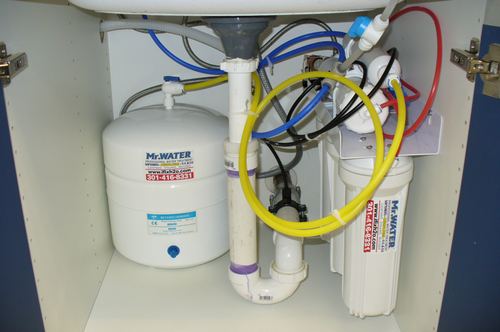 Reverse osmosis storage tank and filter cartridges installed under a kitchen sink