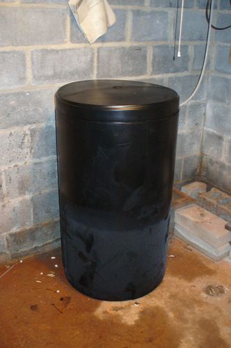 Black cylindrical tank installed in a basement corner