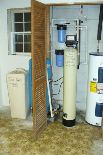 EcoSoft 32K water softener with a brine tank and whole-house filters in a closet