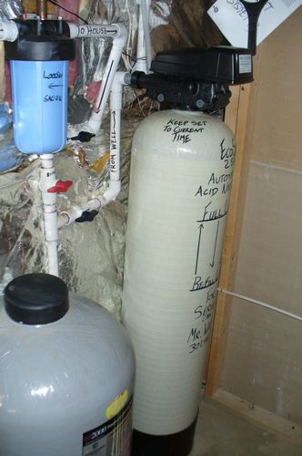 EcoSoft acid neutralizer with a whole-house filter installed in a crawlspace