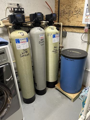 Water softener, air eductor, and acid neutralizer with a brine tank in a laundry room