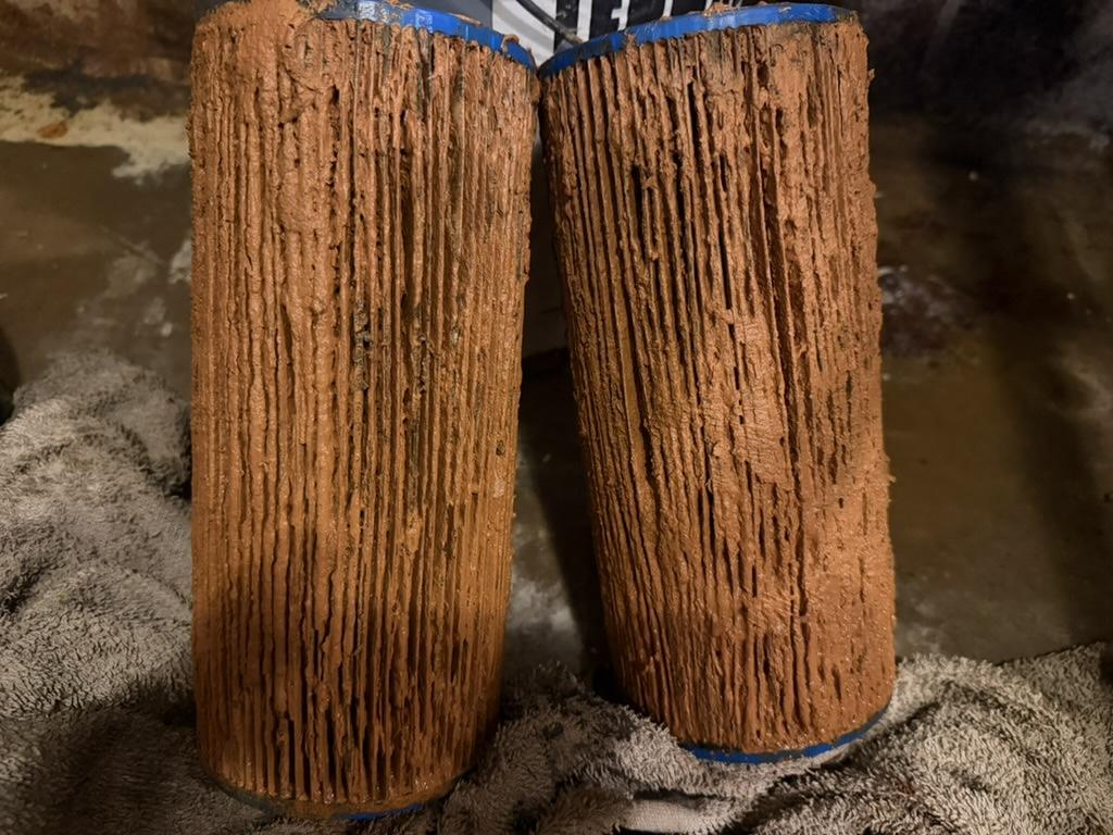 Two heavily iron-fouled sediment filter cartridges removed during a service call