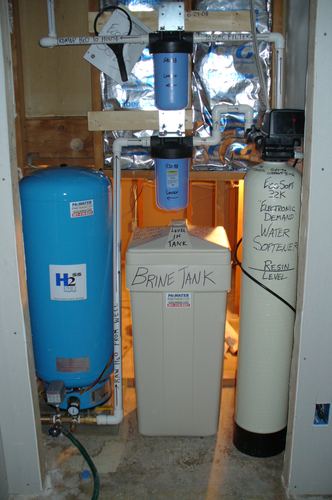 EcoSoft water treatment system with a brine tank installed in a crawlspace