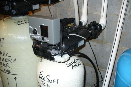 Close-up of a water softener control valve and timer dial