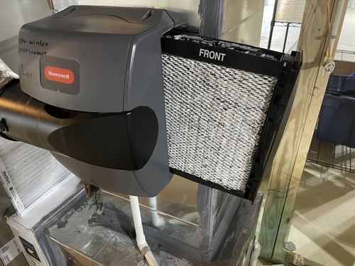 Furnace humidifier pad crusted with hard water mineral buildup