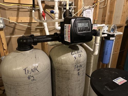 Twin water softener resin tanks labeled Tank 1 and Tank 2 with a shared control valve