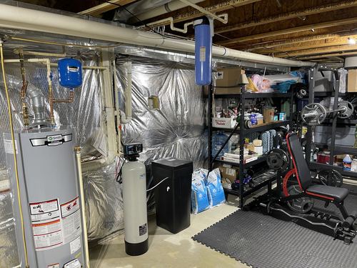 Water softener and carbon filter installed in a basement utility area