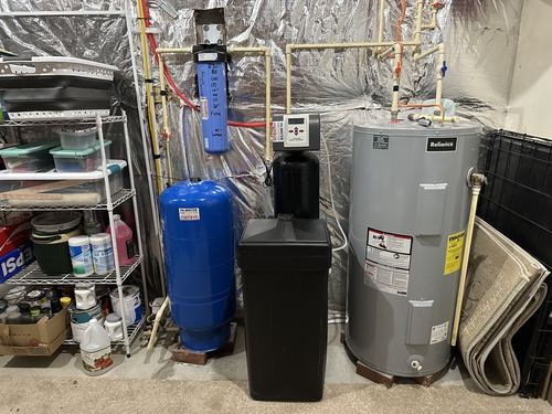 Water softener, pressure tank, and water heater installed in a basement