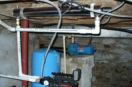 Well pump, pressure tank, and UV light plumbing routed to the house