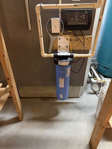 Close-up of a Pentair Big Blue whole-house filter with a well pump controller