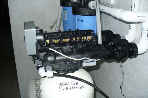 Close-up of a water softener control valve manifold with carbon filters