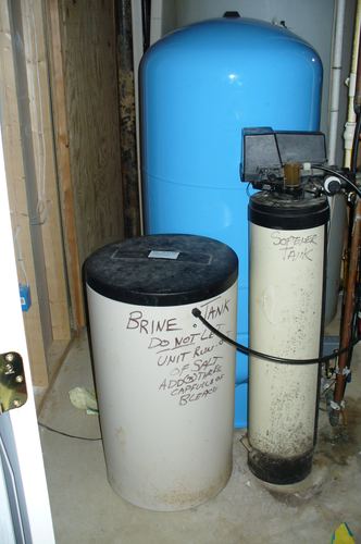 Brine tank and softener tank installed in a basement corner