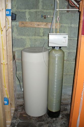 Culligan water softener and filter tank installed in a basement
