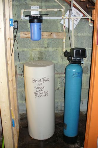 Brine tank and water softener tank installed in a closet