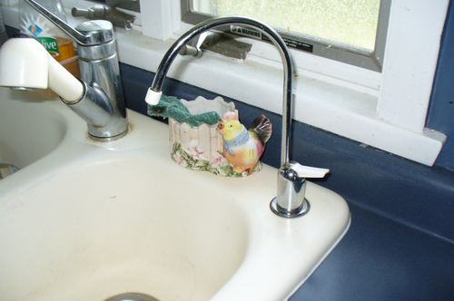 Close-up of a reverse osmosis drinking water faucet at a kitchen sink