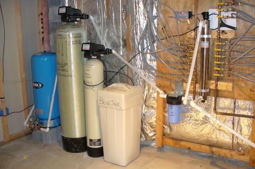 EcoSoft water treatment system with acid neutralizer, water softener, brine tank, and UV light