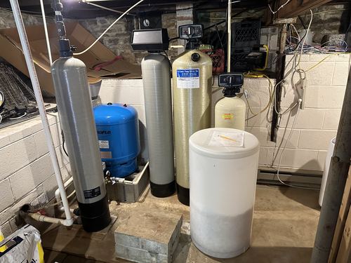 Multiple water treatment tanks and a pressure tank installed together in a basement