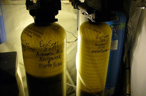 Close-up of EcoSoft acid neutralizer and water softener tank labels