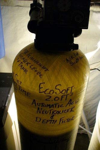Close-up of an EcoSoft acid neutralizer tank label and control valve