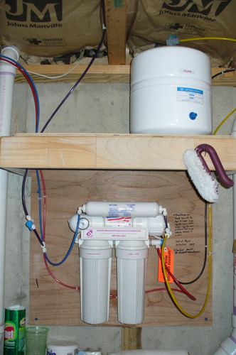 Reverse osmosis storage tank and filter cartridges installed on a wall