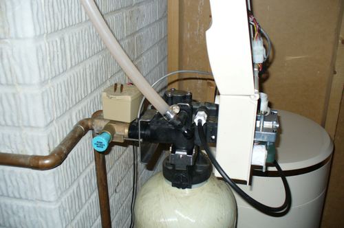 Close-up of a water softener control valve with a soft water push button
