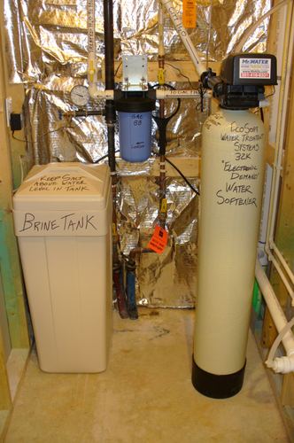 Brine tank and EcoSoft water softener with a whole-house carbon filter installed together