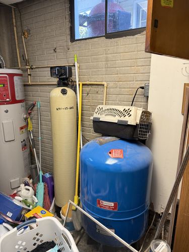 Water heater and pressure tank installed near a water treatment tank