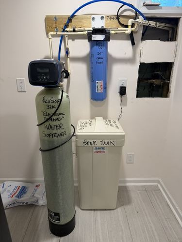 Well pump, water softener, and water heater installed together in a utility room